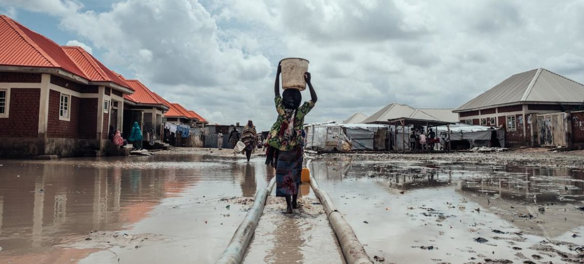 Unicef/KC Nwakalor Milhões estão deslocados em toda a Nigéria devido a conflitos, impactos das alterações climáticas e catástrofes naturais. Nesta foto de arquivo, uma menina leva água para seu abrigo em um campo de deslocados internos no nordeste do país
