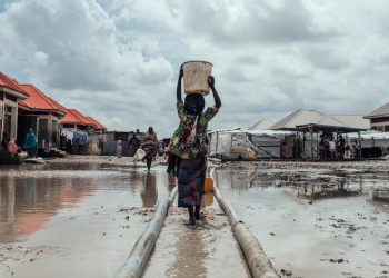 Unicef/KC Nwakalor Milhões estão deslocados em toda a Nigéria devido a conflitos, impactos das alterações climáticas e catástrofes naturais. Nesta foto de arquivo, uma menina leva água para seu abrigo em um campo de deslocados internos no nordeste do país