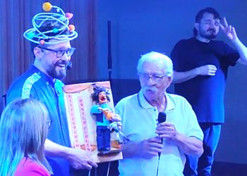 Na foto de OFATOMARINGA.COM, Danilo Furlan recebe o troféu das mãos do artista precursor do teatro de bonecos no Brasil, Leonil Lara