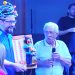 Na foto de OFATOMARINGA.COM, Danilo Furlan recebe o troféu das mãos do artista precursor do teatro de bonecos no Brasil, Leonil Lara